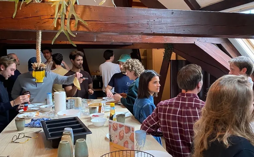 Members sharing pancakes around the breakfast table